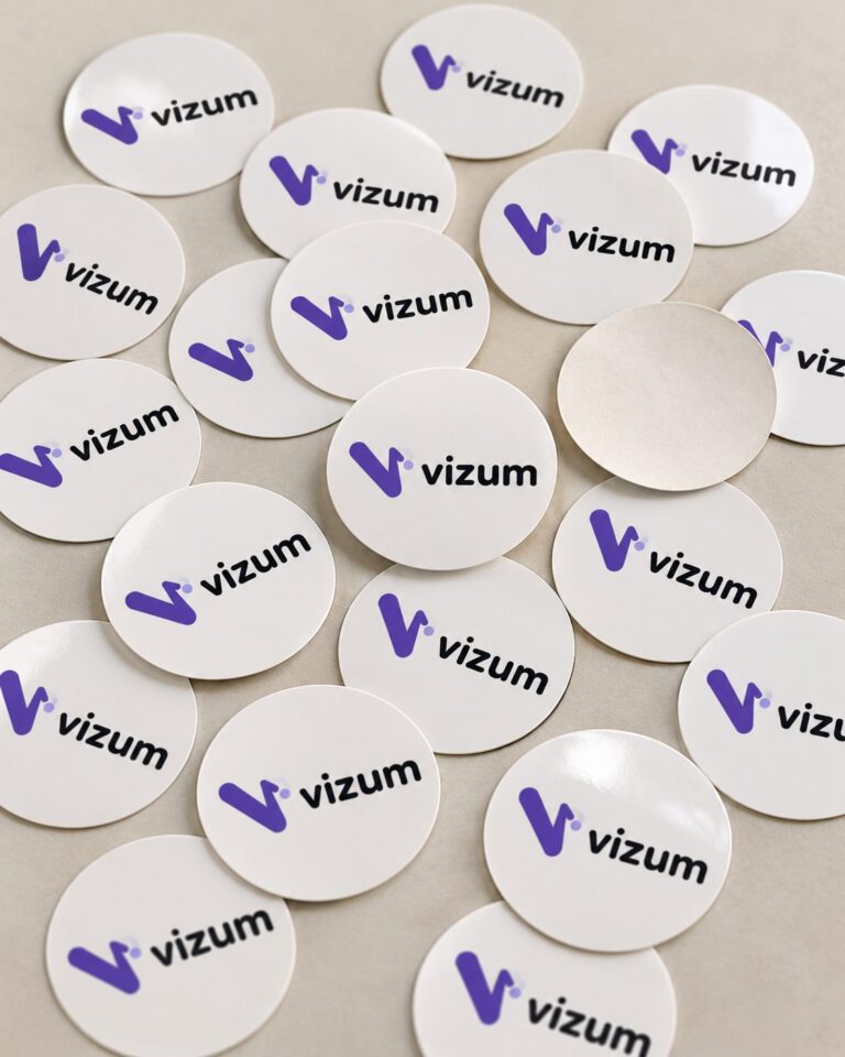 Pojedynczo cięte okrągłe naklejki z logo rozsypane na stole
